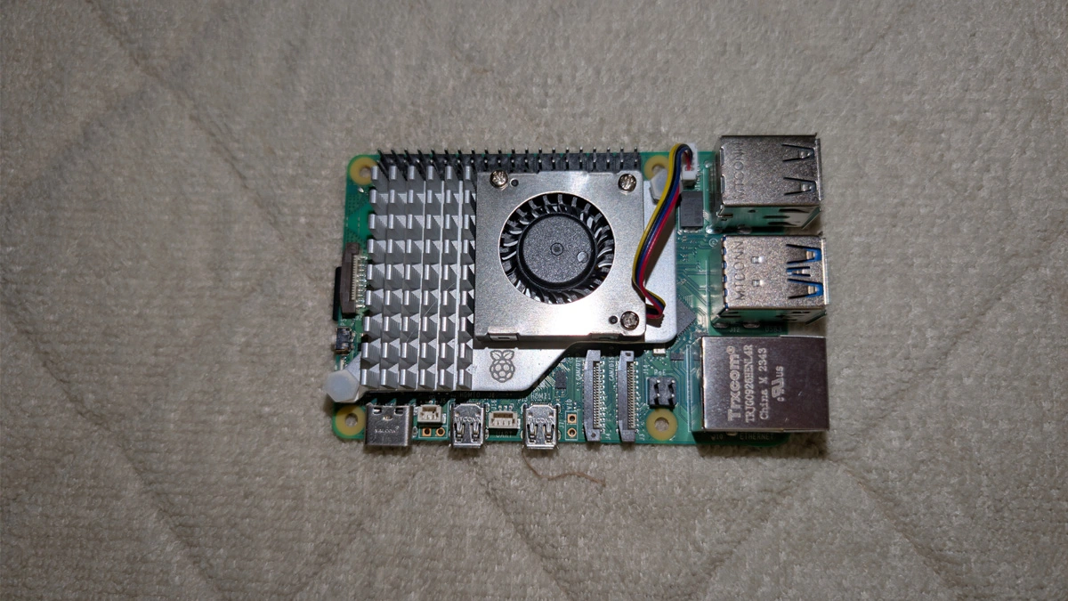 Raspberry Pi 4 single-board computer with aluminum heatsink and active cooling fans on a desk